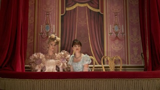 Jessica Madsen as Cressida Cowper and Claudia Jessie as Eloise Bridgerton sit in a theater box in Bridgerton’s third season.