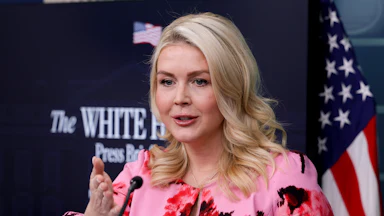 Karoline Leavitt gestures and speaks at a podium during a White House press briefing.