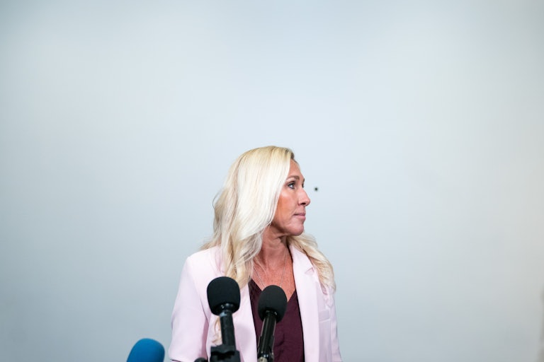 Marjorie Taylor Greene stands at a press conference.