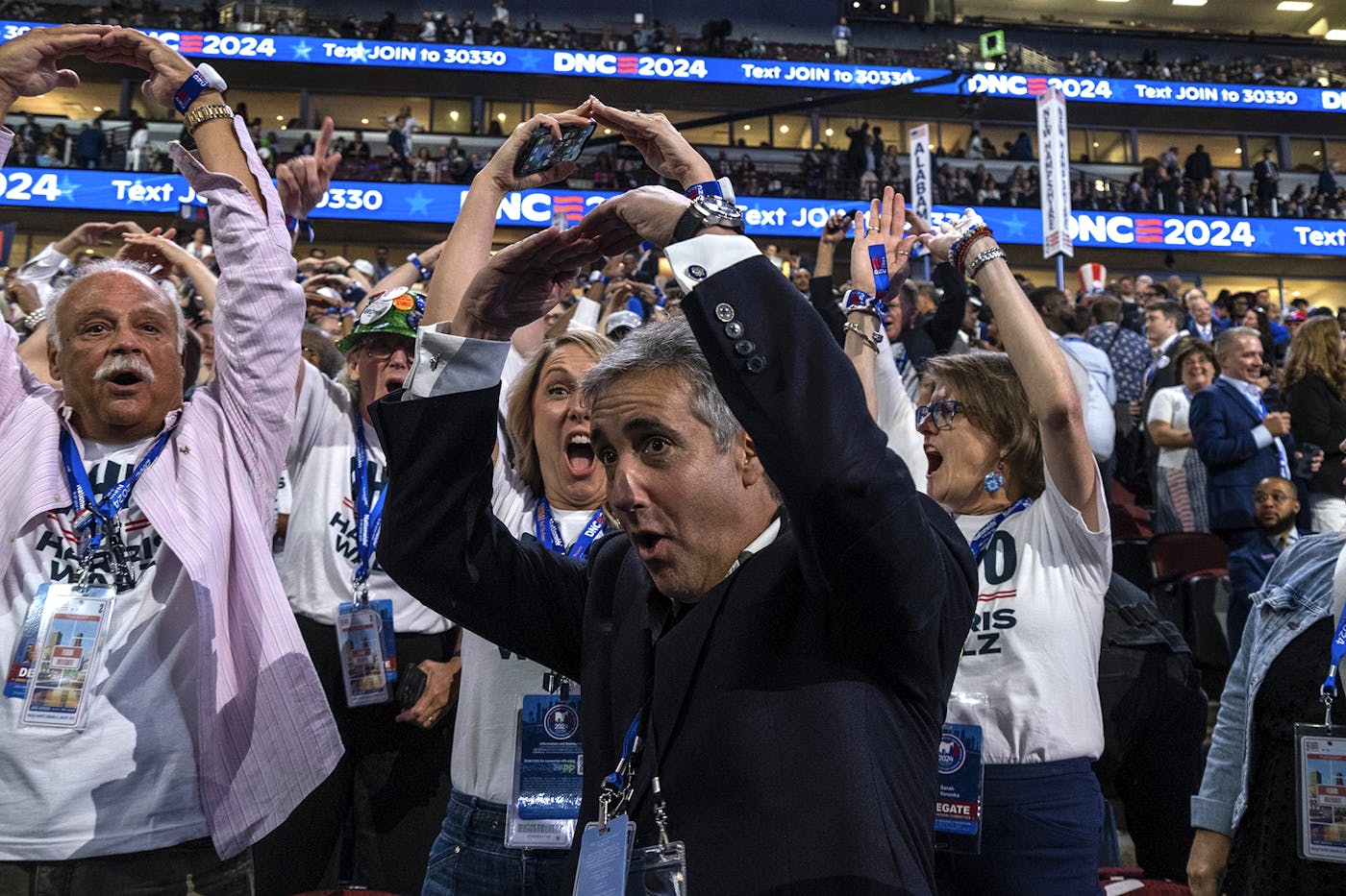 Michael Cohen, Trump’s former lawyer, joins delegates in making a heart shape with hands overhead