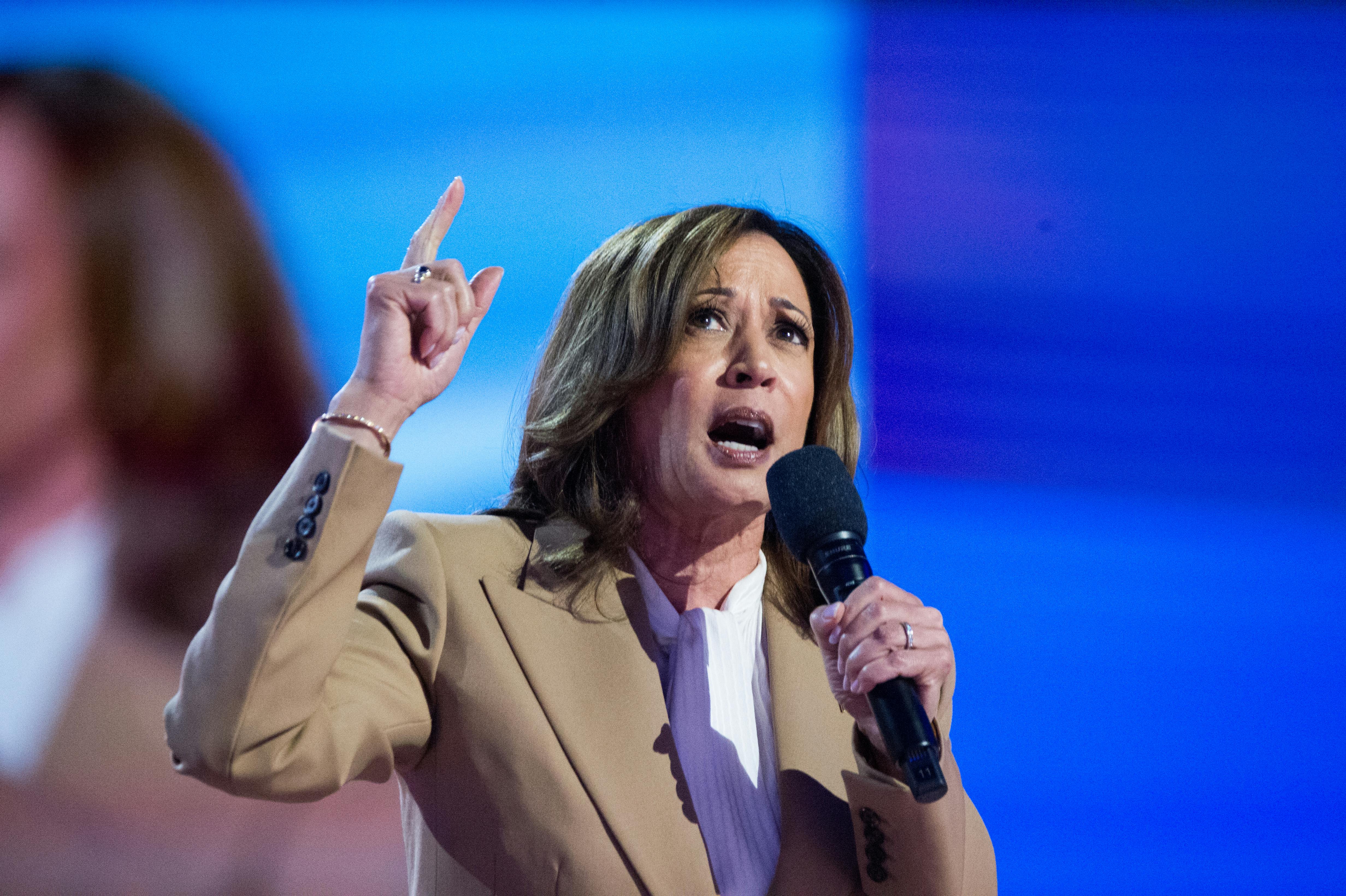 Kamala Harris speaks while holding up a finger.