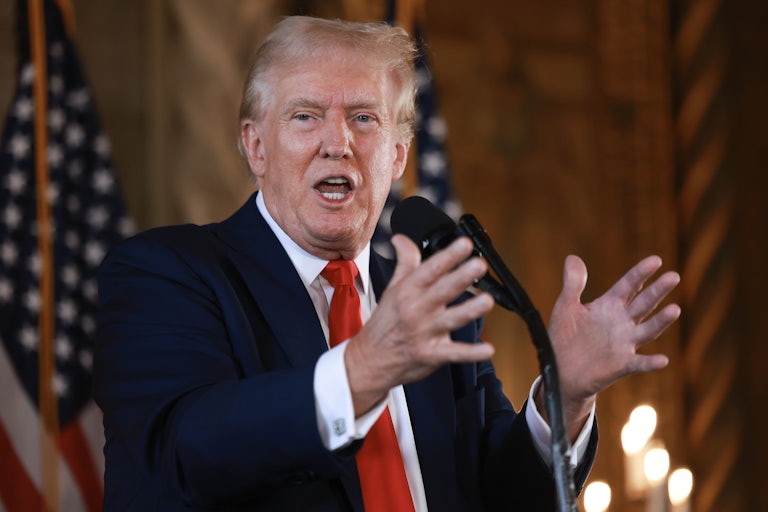 Donald Trump speaking and making hand gestures at a mic