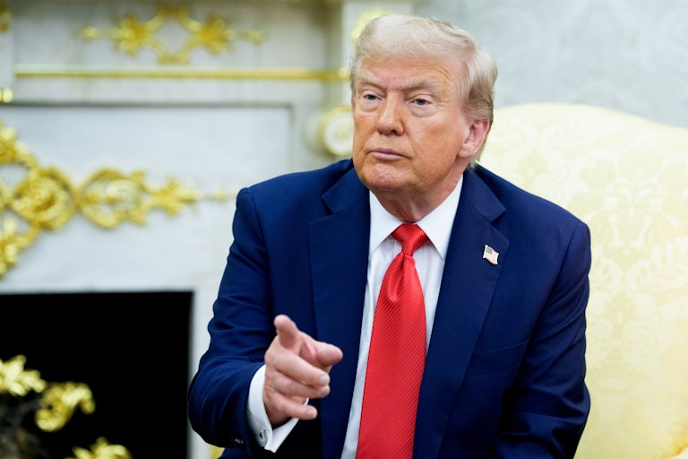 Donald Trump points as he sits in his gold-covered Oval Office.