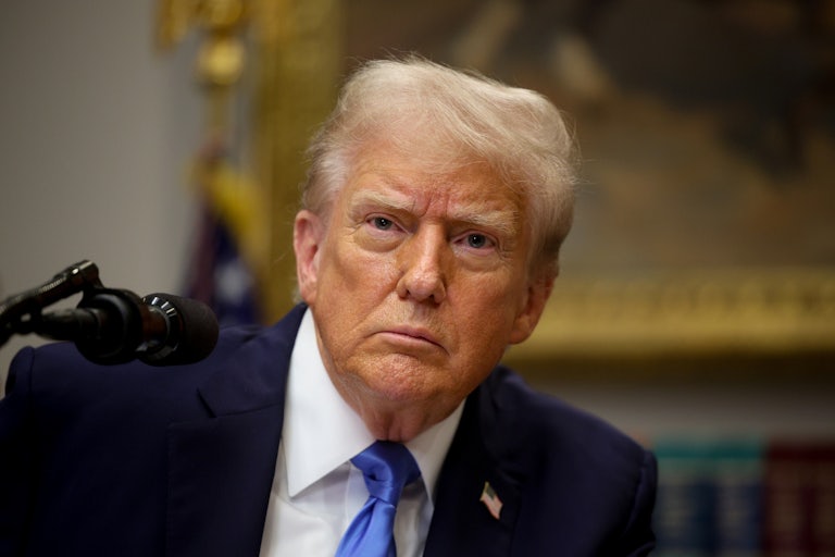 Donald Trump looks at reporters while standing at a podium in the White House