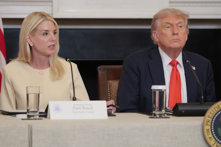 Attorney General Pam Bondi sits next to Donald Trump at an event at the White House