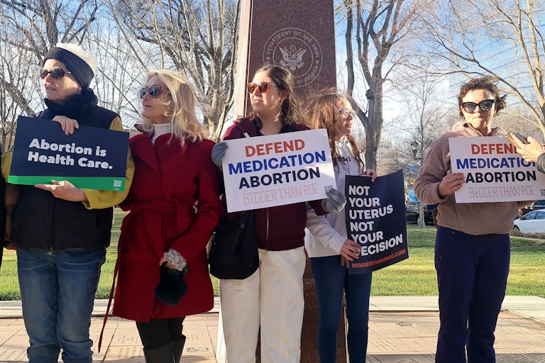 Protesters hold signs that read "Abortion is Health Care," "Defend Medication Abortion, Bigger than Roe," and "Not Your Uterus Not Your Decision."