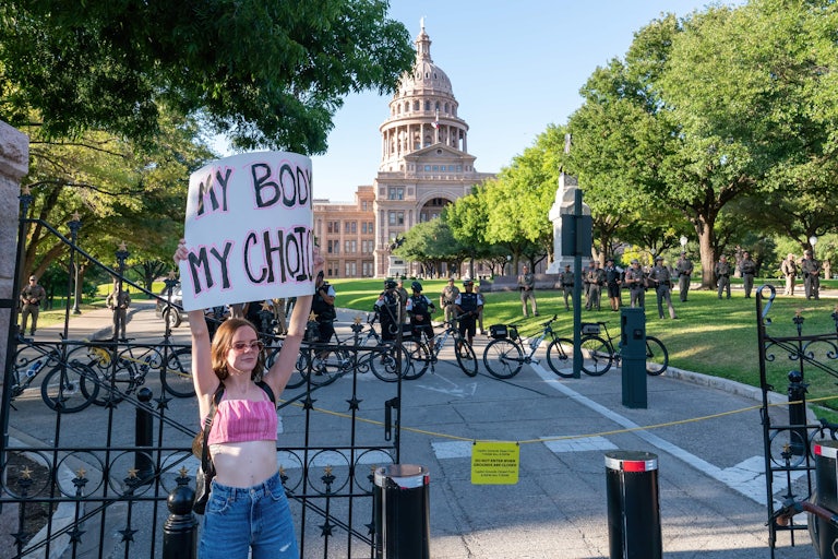 A pro-reproductive rights protester stands outside the Texas Supreme Court
