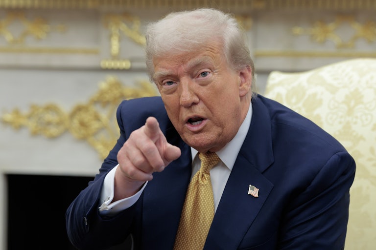 Donald Trump speaks and points a finger while sitting in the Oval Office of the White House.