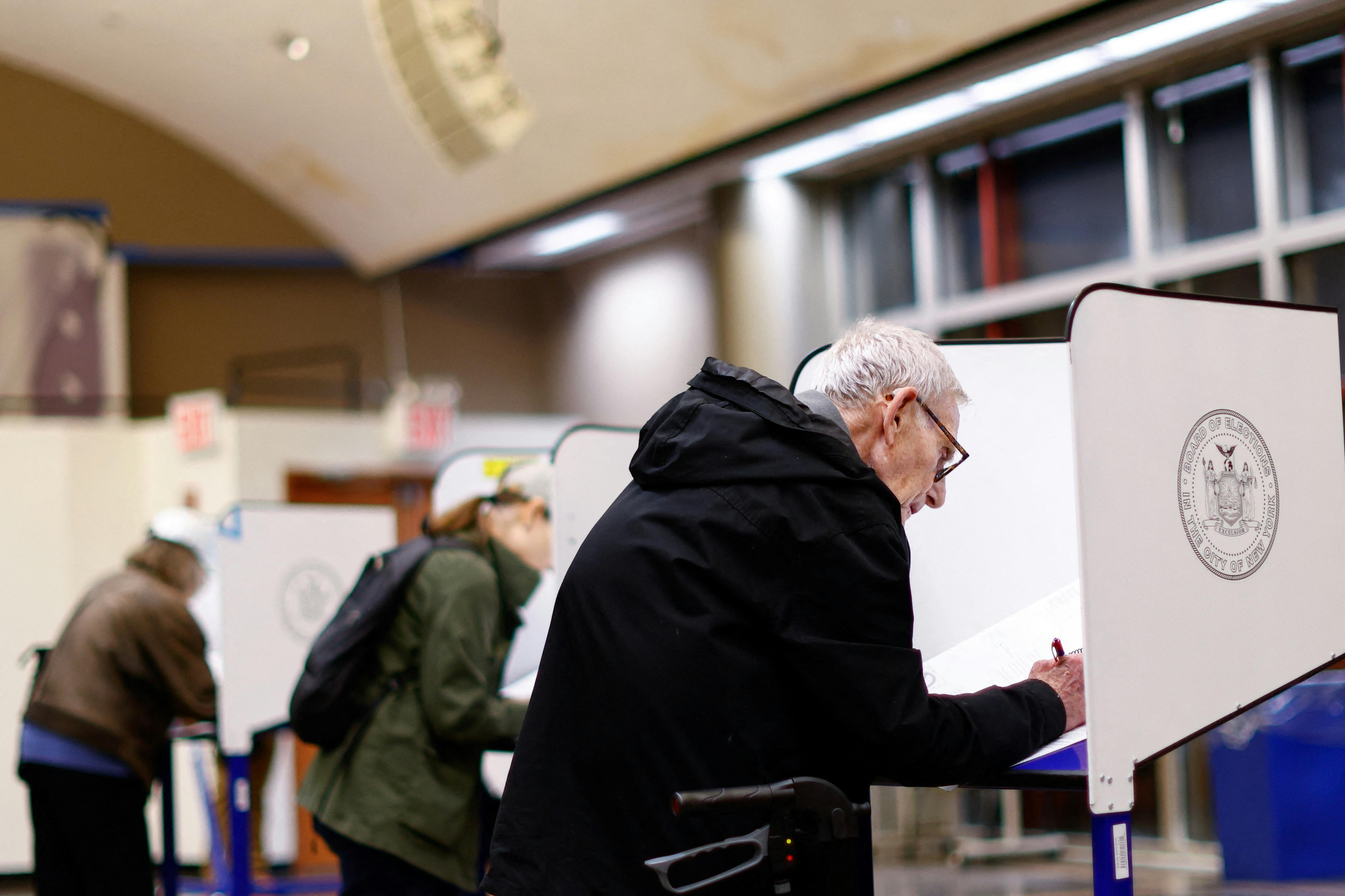 People lean over ballot desks.