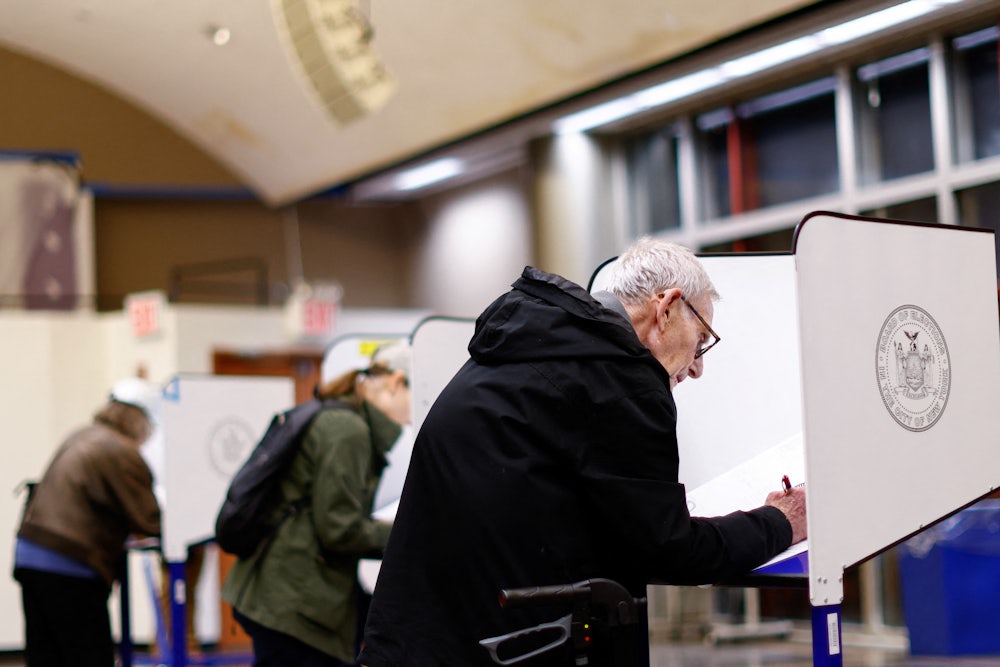 People lean over ballot desks.