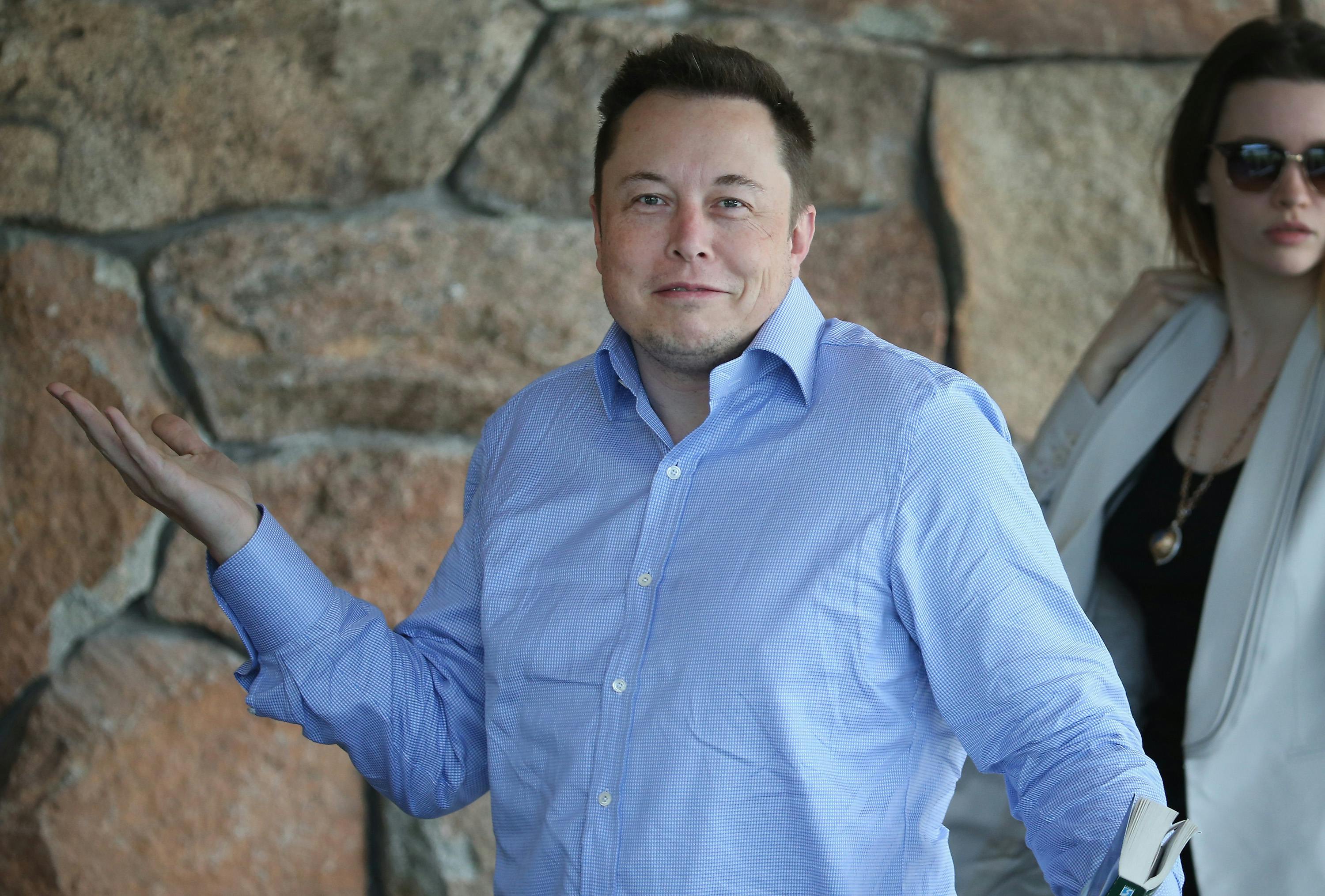 Tesla CEO Elon Musk shrugs his shoulders with a bemused expression on his face 