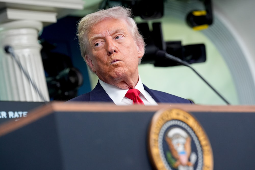 Donald Trump purses his lips while standing during a news conference in the James S. Brady Press Briefing Room of the White House.