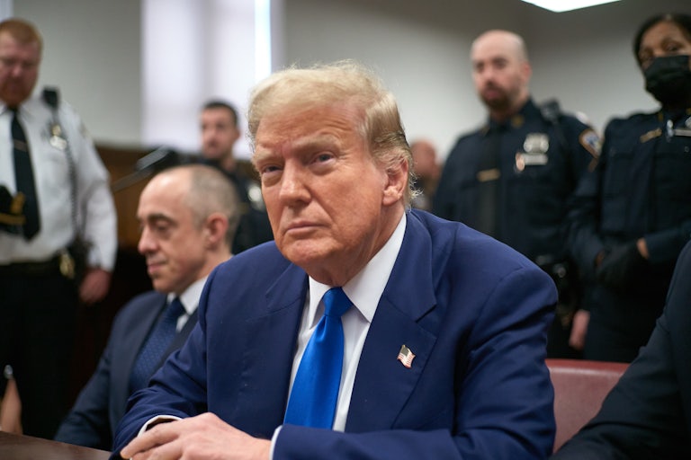 Donald Trump sits at a table