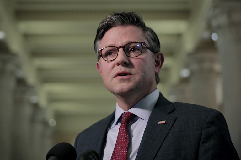 House Speaker Mike Johnson looks shocked while speaking into a microphone