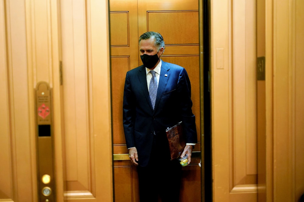 A masked Mitt Romney stands alone in an elevator.