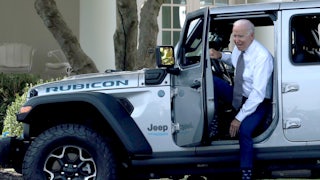 President Biden climbs out of a Jeep.