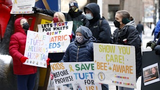 Demonstrators hold signs in support of Tufts Children's Hospital.