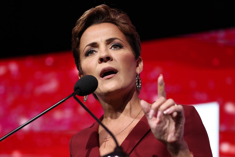 Kari Lake speaks at a lectern and points a finger