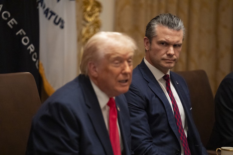 Donald Trump speaks while sitting next to Pete Hegseth