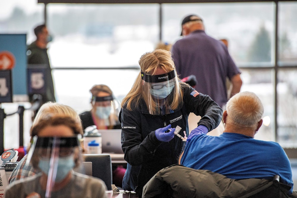 A health worker administers the Covid vaccine.