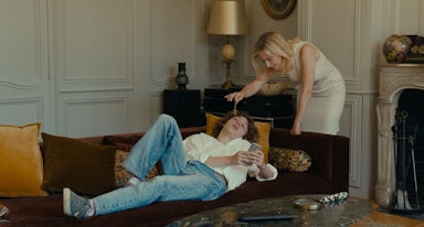 An episodic image from the movie Last Summer of a mature woman standing over a young boy