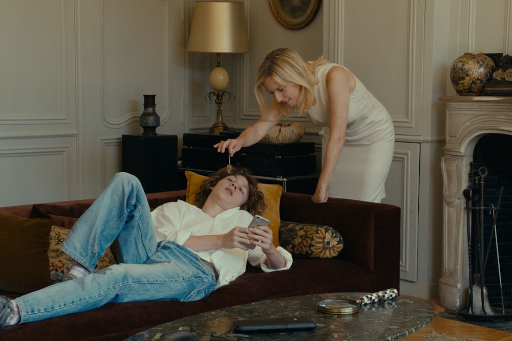 An episodic image from the movie Last Summer of a mature woman standing over a young boy