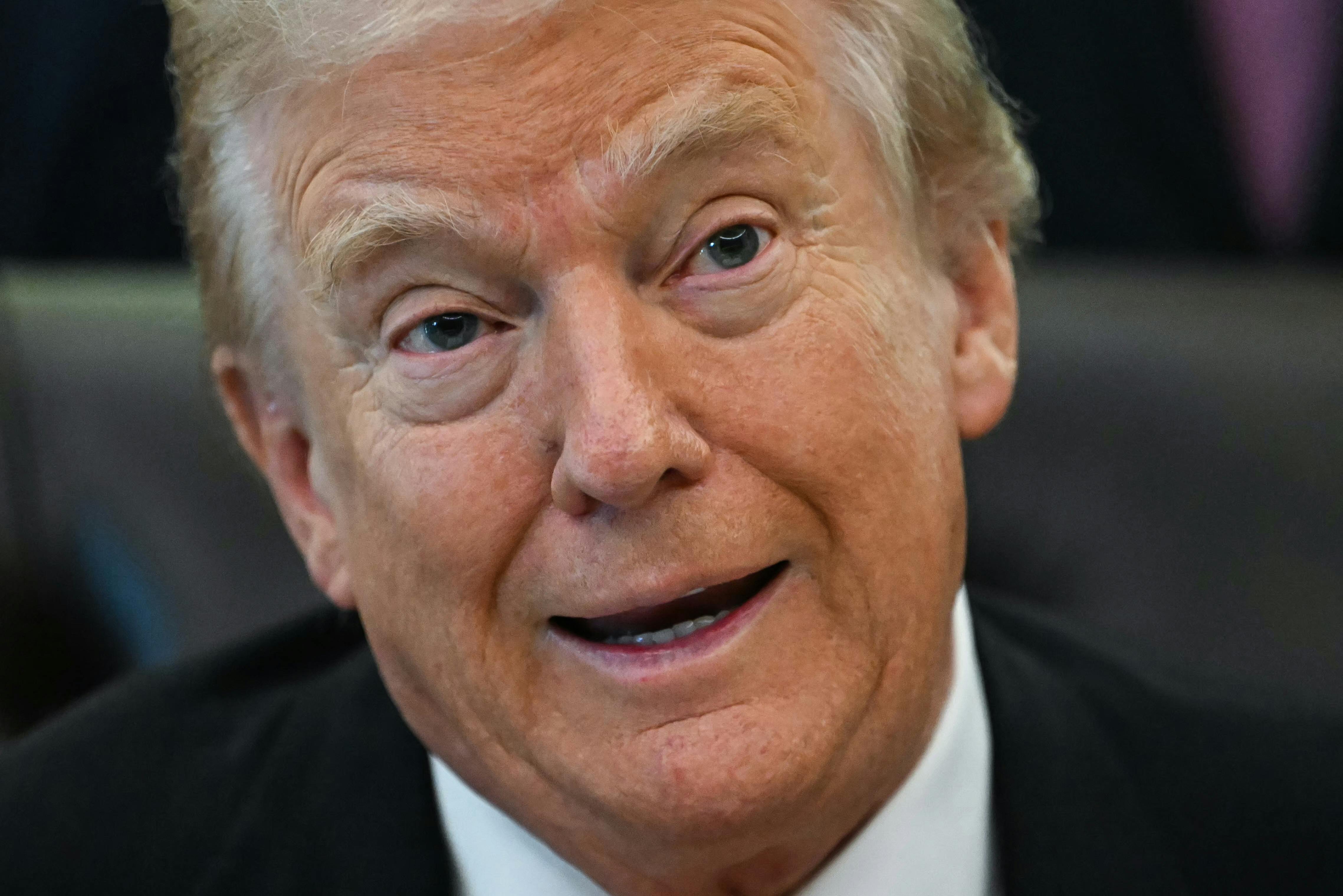 Donald Trump speaks while sitting at his desk in the Oval Office