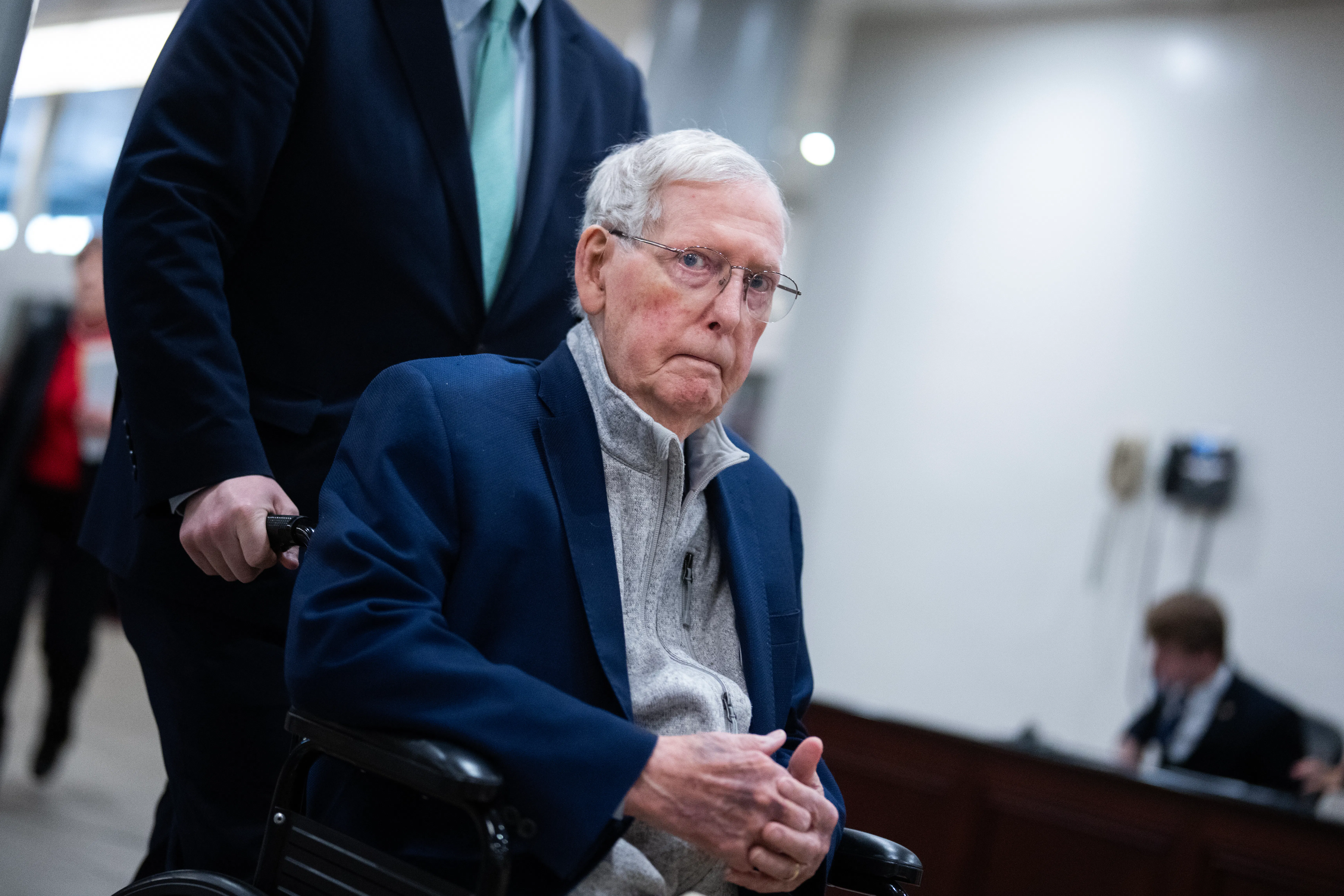 Senator Mitch McConnell is pushed through the U.S. Capitol in a wheelchair.
