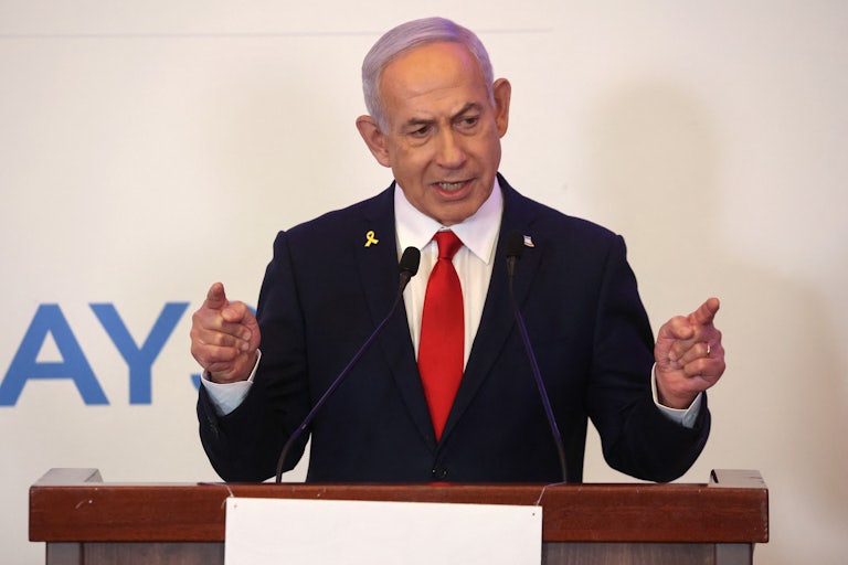Israeli Prime Minister Benjamin Netanyahu points with both fingers while speaking at a podium