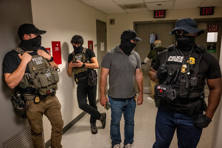 Federal officers wait outside of immigration courtrooms in New York
