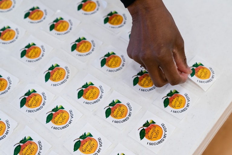 A person lays out voting stickers at a polling station in Georgia