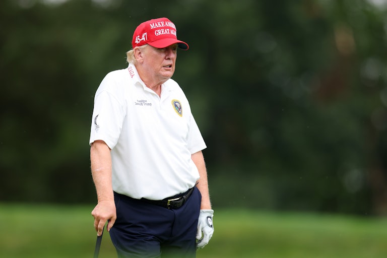 Donald Trump leans on a golf club