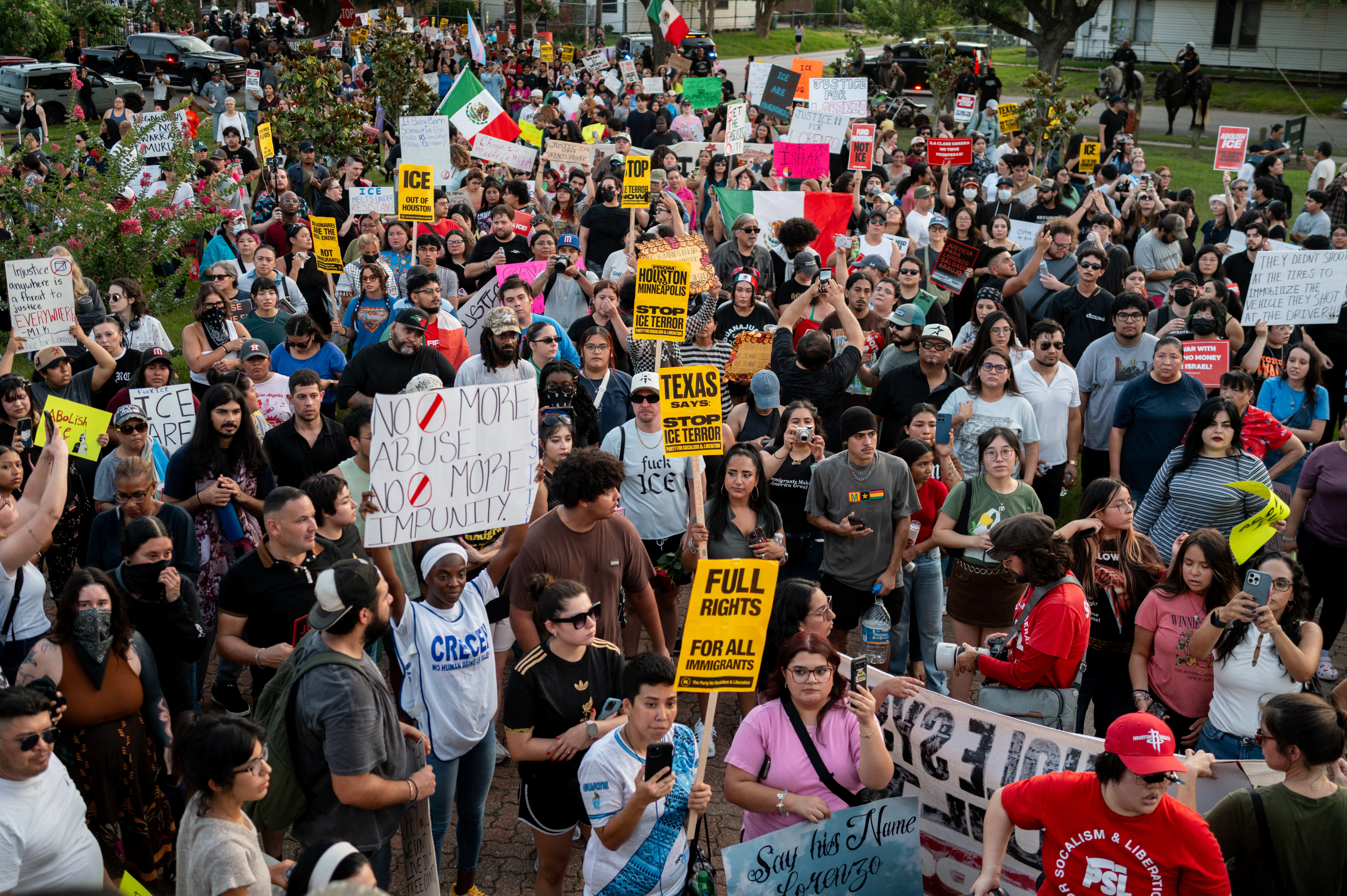 A large group of people People march to honor Mexican immigrant Lorenzo Salgado Araujo, holding signs and the Mexican flag.