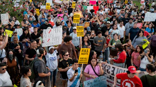 A large group of people People march to honor Mexican immigrant Lorenzo Salgado Araujo, holding signs and the Mexican flag.