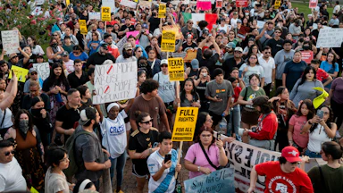 A large group of people People march to honor Mexican immigrant Lorenzo Salgado Araujo, holding signs and the Mexican flag.