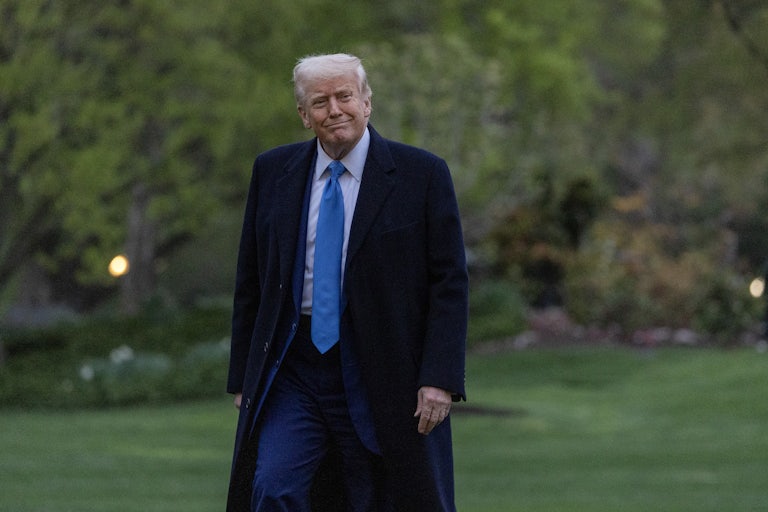 Donald Trump smiles while walking outside the White House