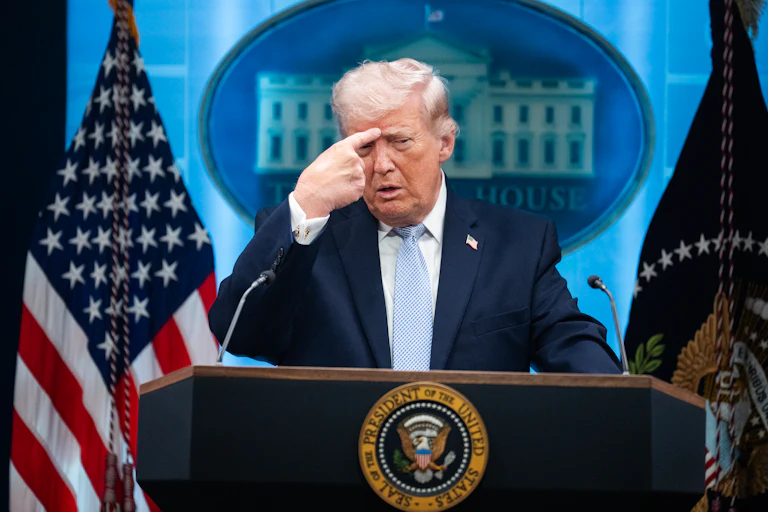 Trump points at forehead