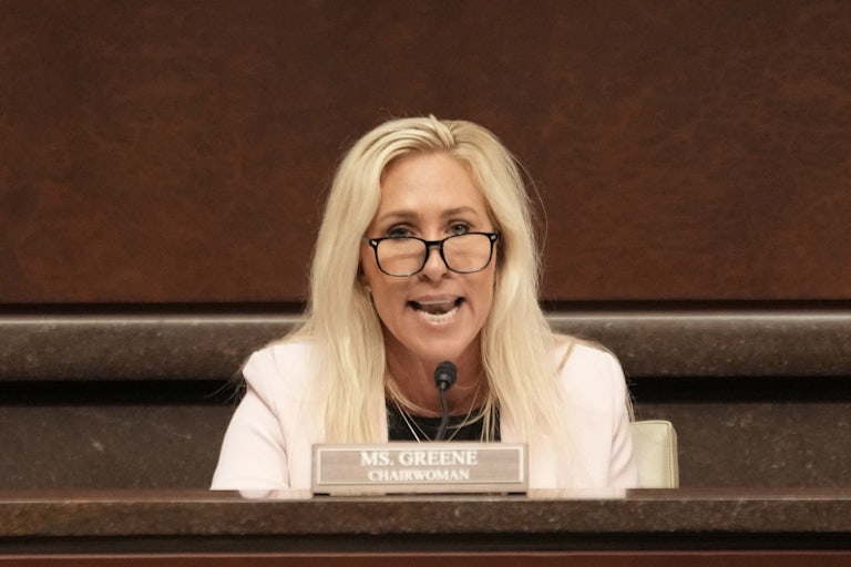 Representative Marjorie Taylor Greene speaks into a microphone during a House hearing