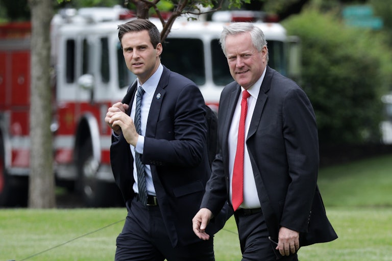 John McEntee and Mark Meadows walk across the White House South Lawn.