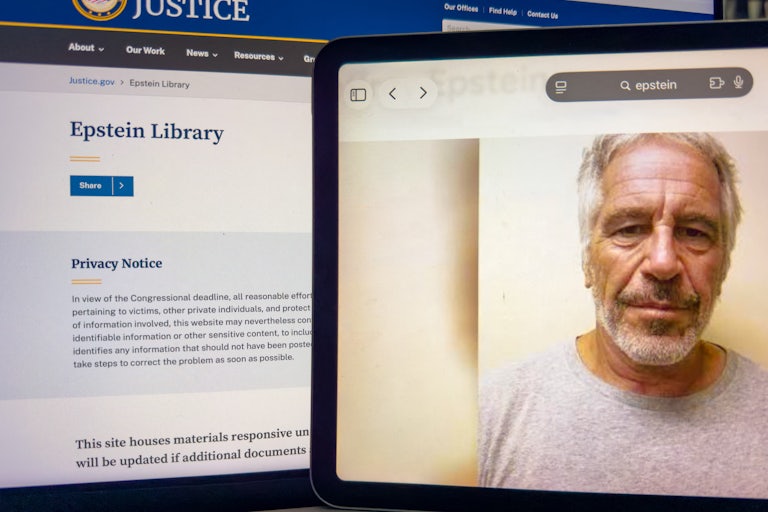 Two computer screens show the Department of Justice's library of files on Jeffrey Epstein and a photograph of his face
