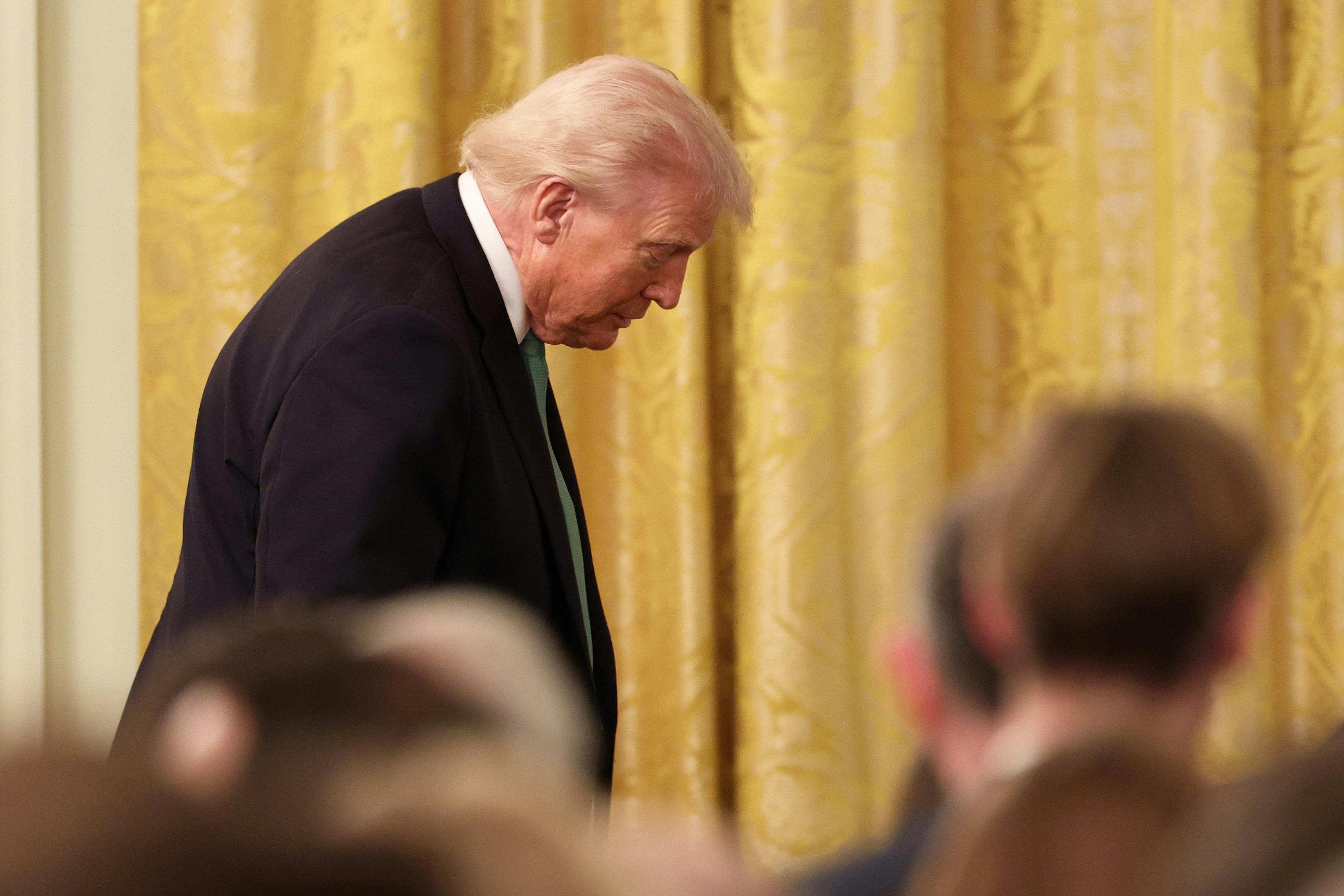Donald Trump, seen in profile, looks down during an event
