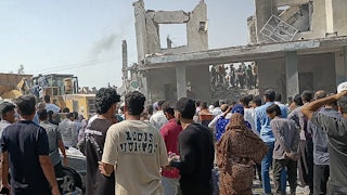 People gather at the destroyed site of a girls' school in Iran