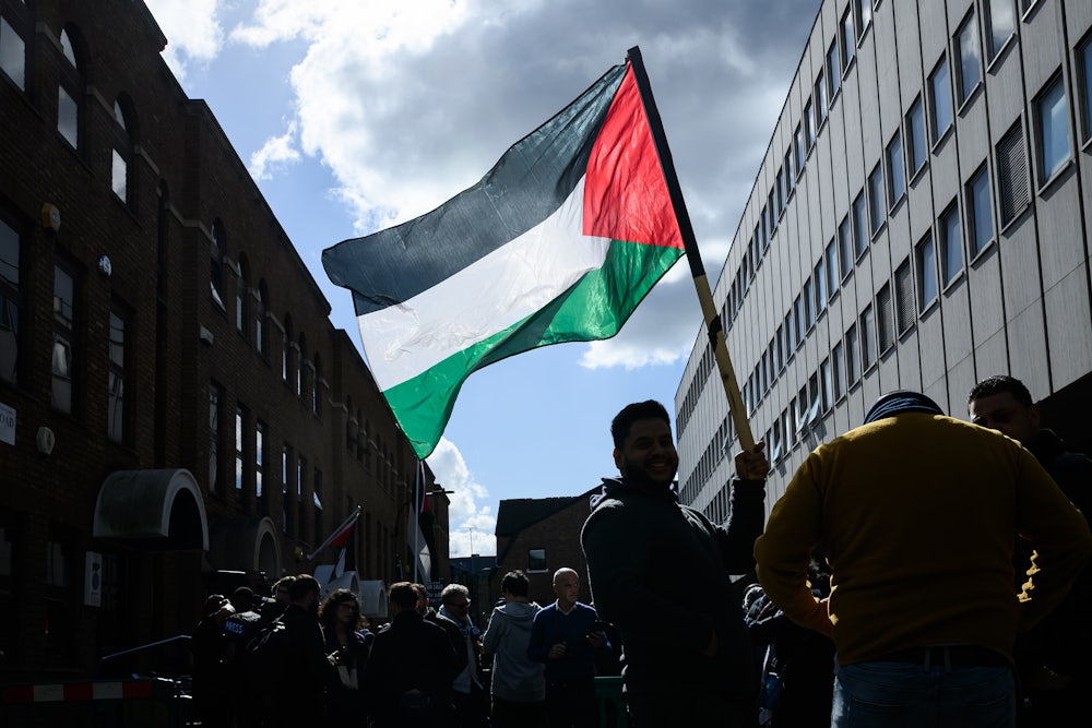 A man holds a Palestinian flag outside the Palestine Mission to the UK following the flag-raising ceremony to mark UK’s recognition of a Palestinian State on September 22, 2025 in London, England.