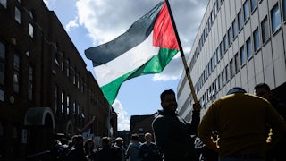 A man holds a Palestinian flag outside the Palestine Mission to the UK following the flag-raising ceremony to mark UK’s recognition of a Palestinian State on September 22, 2025 in London, England.