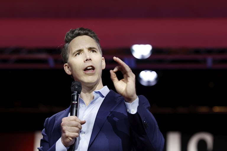 Josh Hawley speaks while holding a mic and making a hand gesture