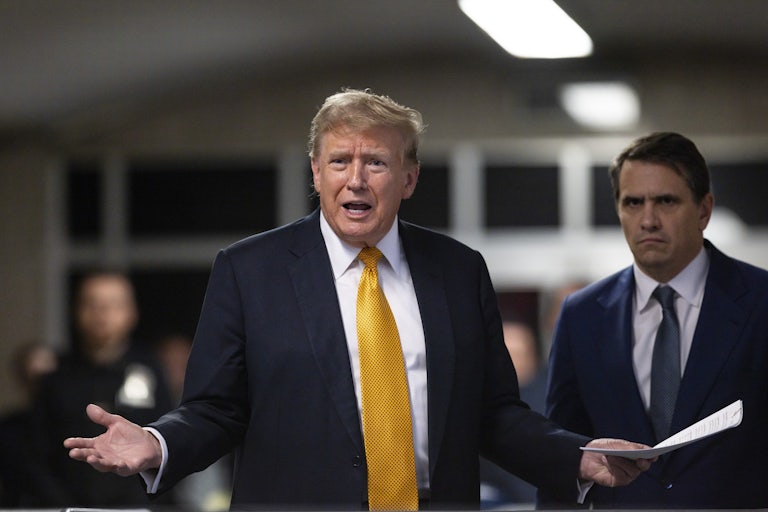 Donald Trump yells and spreads his arms out as if in exasperatin. He holds a stack of papers in one hand, and his lawyer Todd Blance stands next to him looking angry.