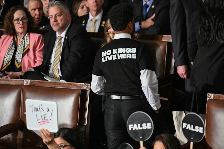 Representative Maxwell Frost wears a shirt reading "No kings live here" as he walks out of the House Chamber while US President Donald Trump speaks during an address to a joint session of Congress