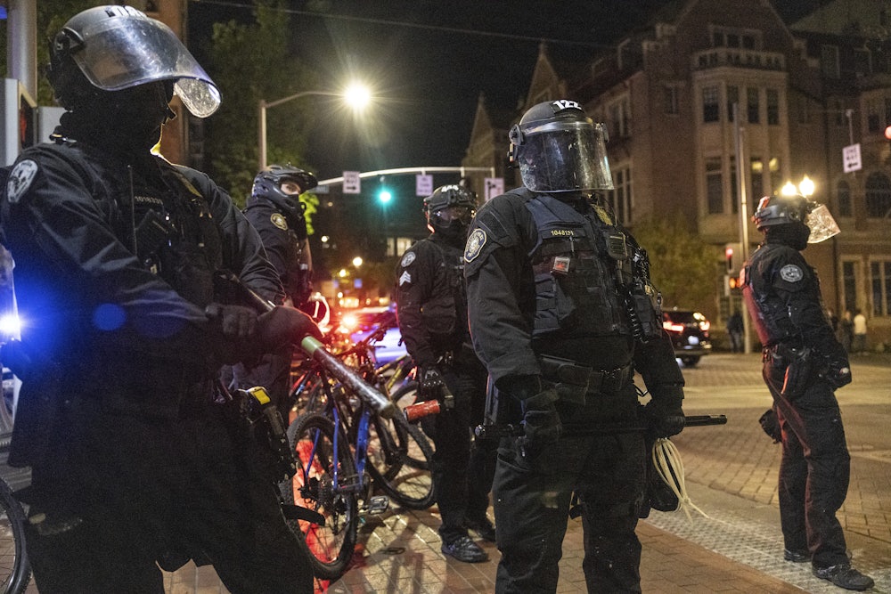 Police stand in position against a small group of protesters