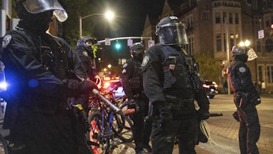 Police stand in position against a small group of protesters
