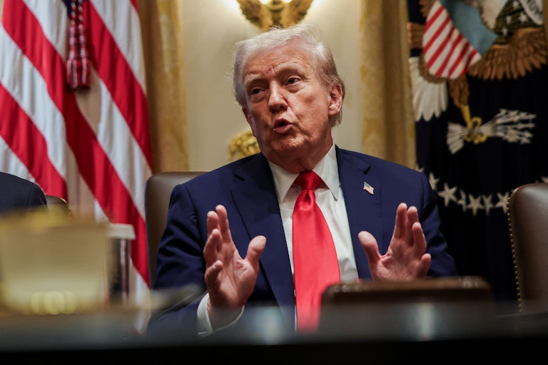Donald Trump gestures and speaks while sitting in a Cabinet meeting